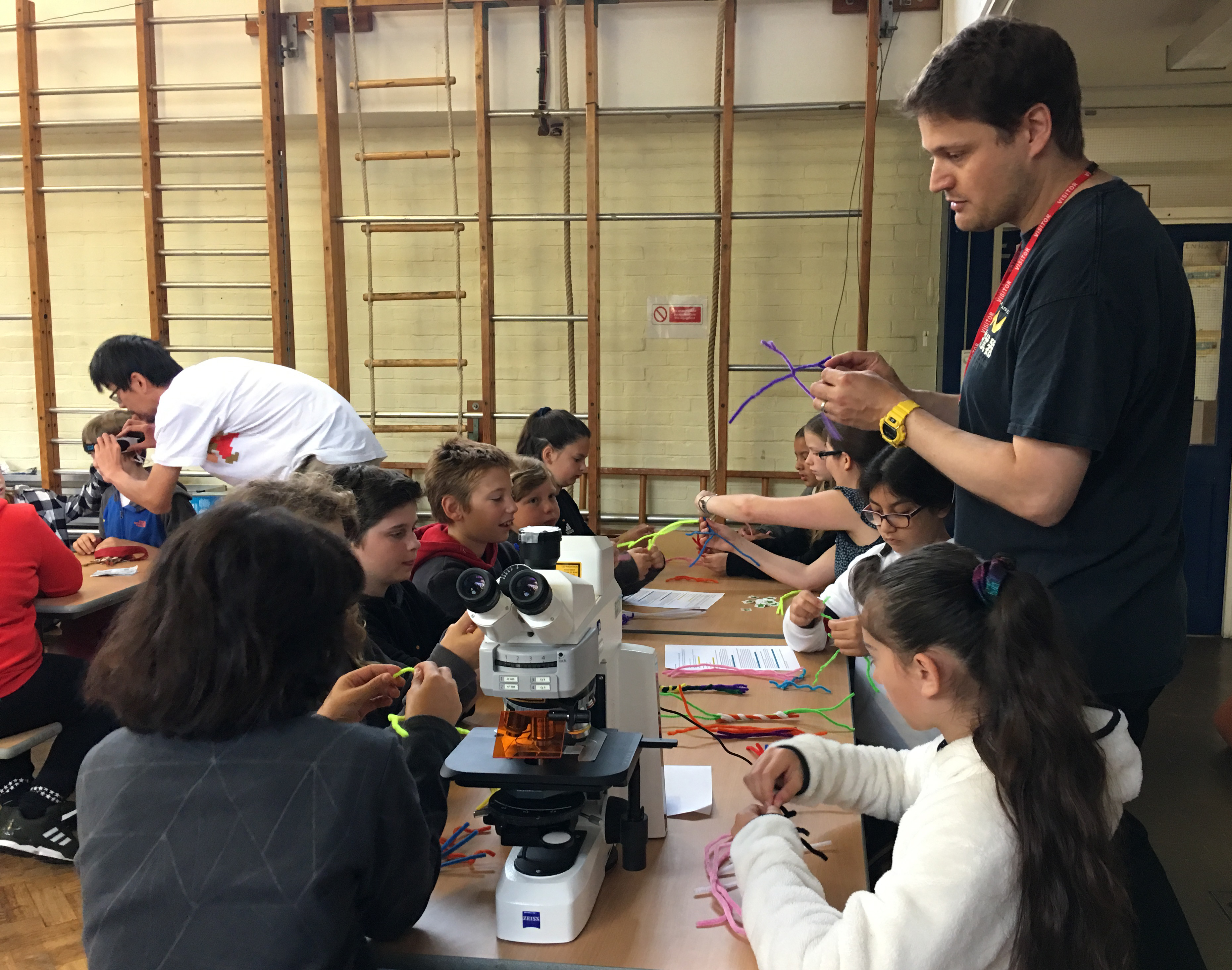 Photo of Unit researcher Ben Micklem helping a group of pupils to make nerve cells from pipe cleaners.