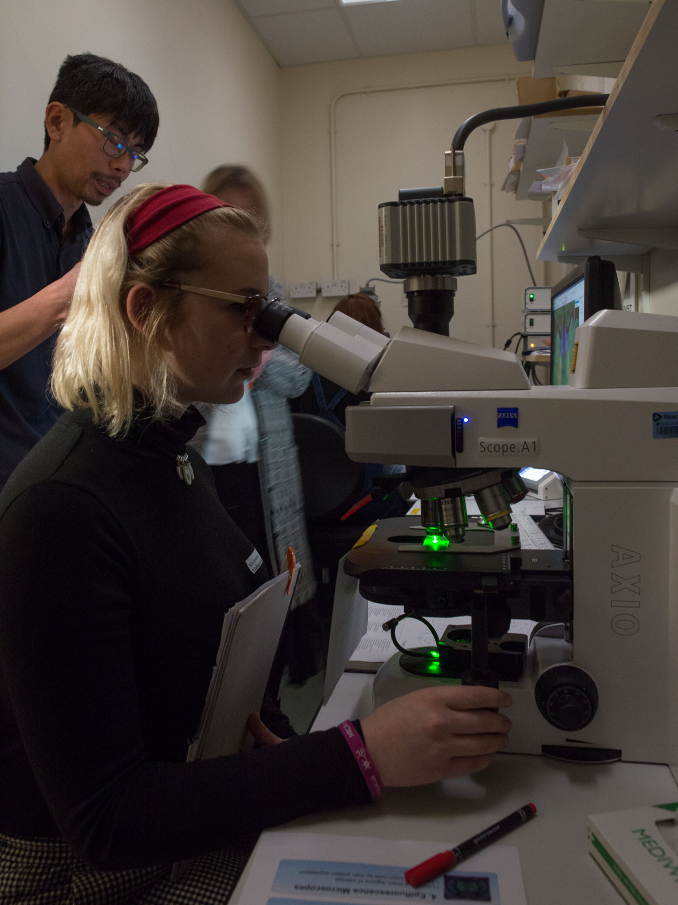 Visiting pupils were encouraged to view the complexity of the brain for themselves. Here, Unit scientist Dr Kouichi Nakamura guides pupils in observing nerve cells on an epifluorescence microscope.