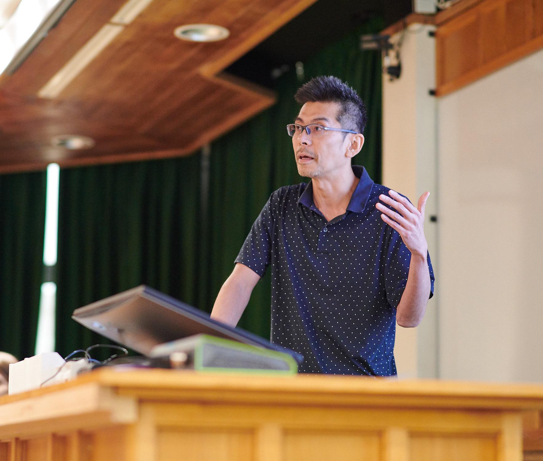 A photo of Kouichi Nakamura presenting his research to Unit colleagues.