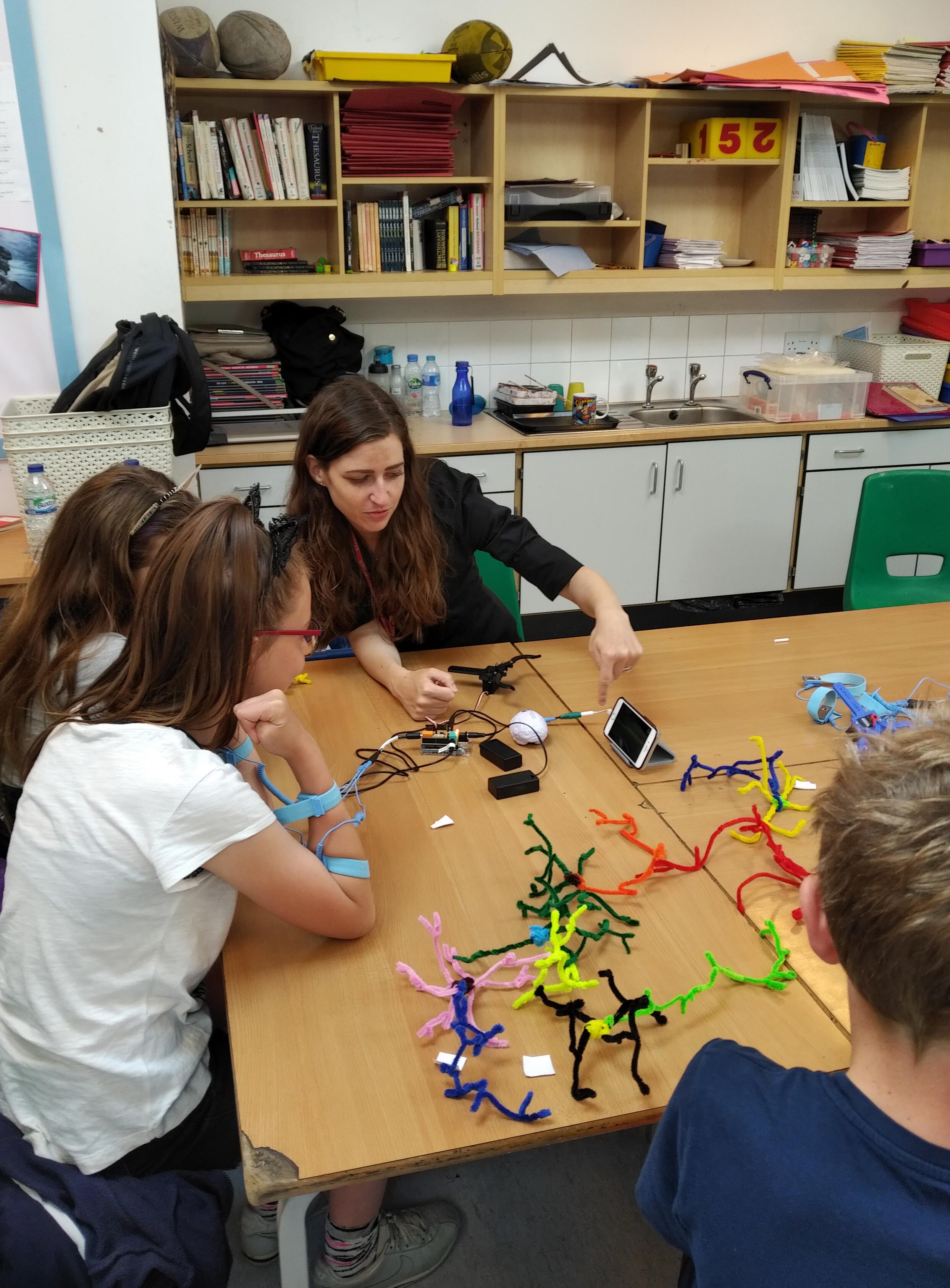 Unit scientist Dr Abbey Holt helps a pupil to remotely control a robotic device by mind and muscle