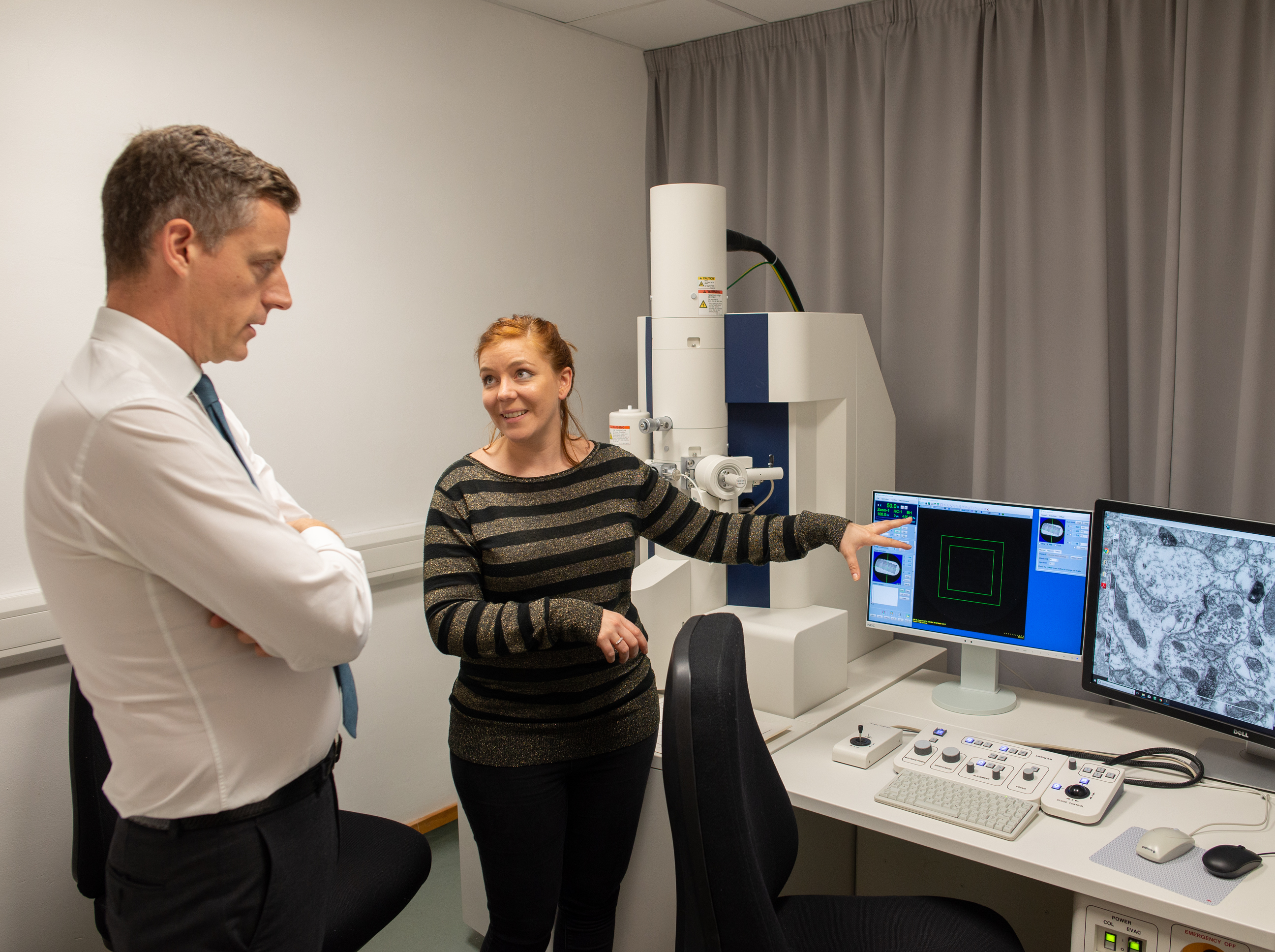 Unit postdoctoral scientist Natalie Doig guides Lord O’Shaughnessy through the use of the electron microscope to reveal the fine-grained structure of the brain.