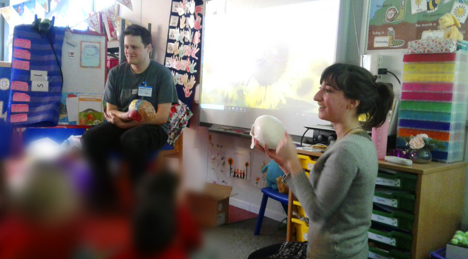 Flavie and Ben show a Reception class (ages 4 and 5) a model of the human brain.