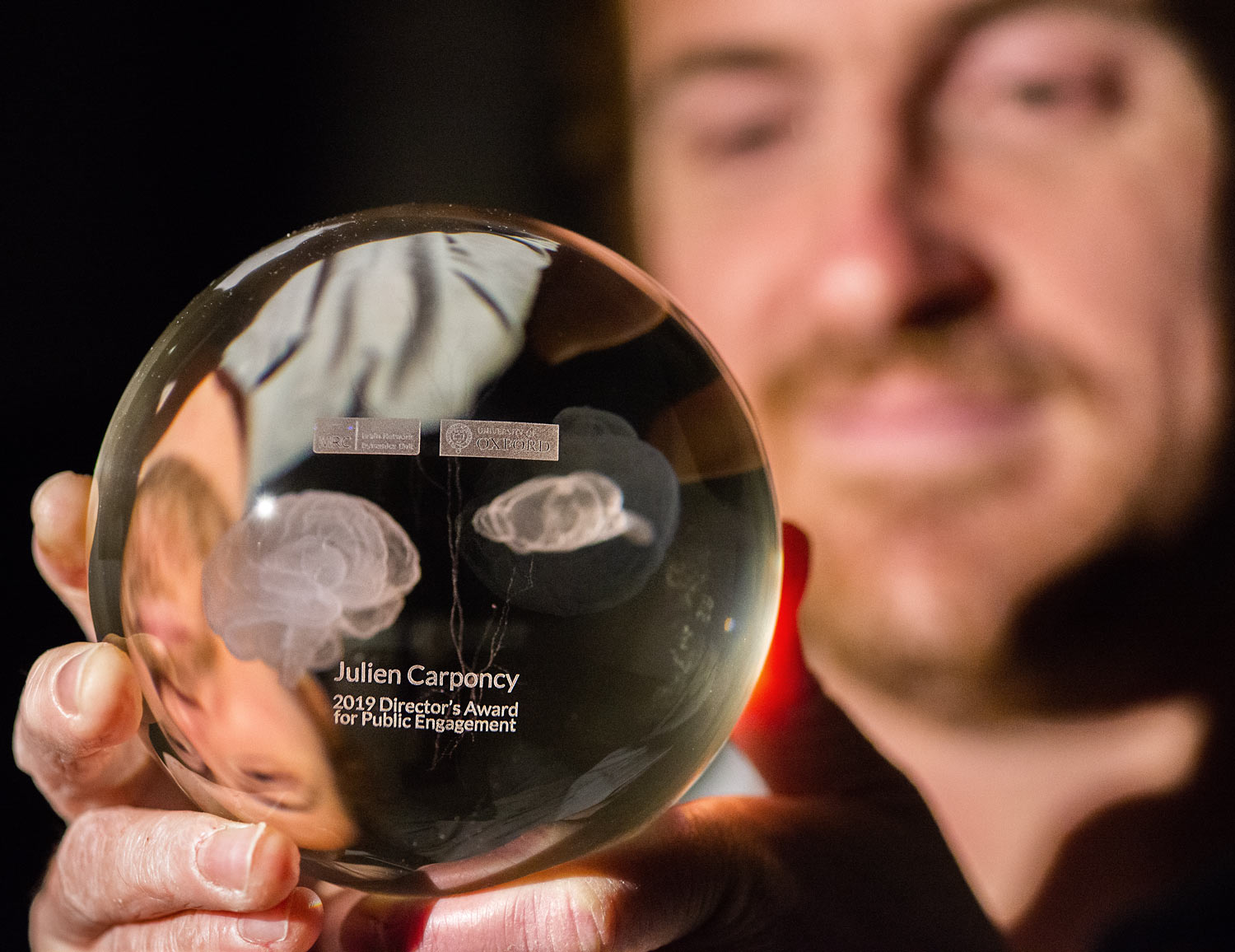 Photo of Julien Carponcy holding his trophy as winner of the Director’s Award for Public Engagement for 2019.