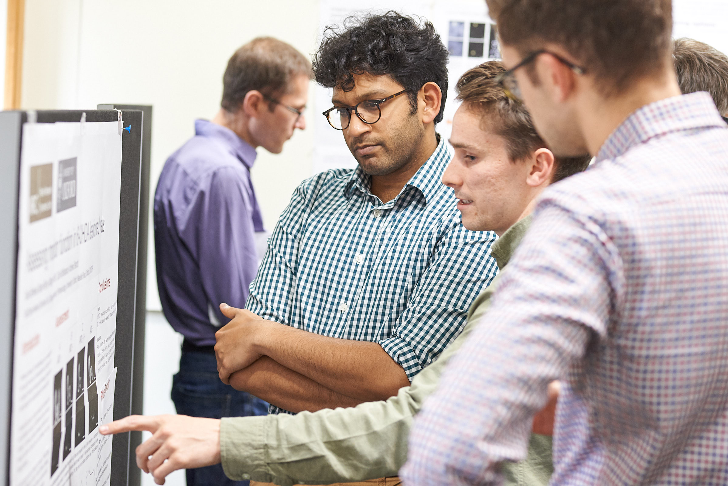 Unit student Max Rothwell (centre) engages colleagues with his poster at summer Science Day 2017.