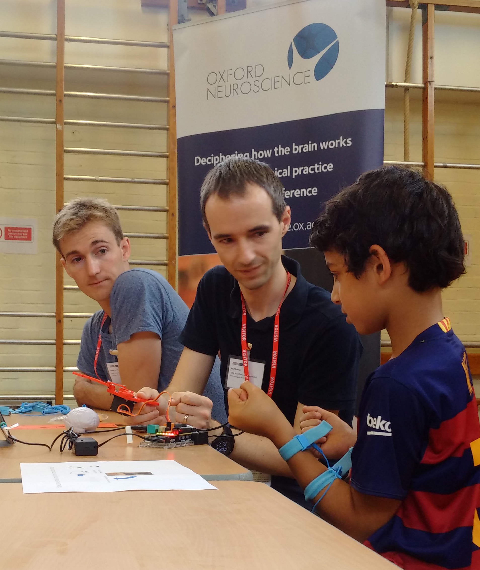 Unit scientists Gido van de Ven (left) and Dr Paul Dodson (centre) help a pupil to remotely control a robotic device by mind and muscle.