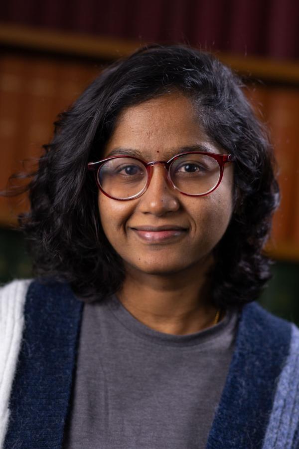 Portrait photo of Alekhya with books in the background