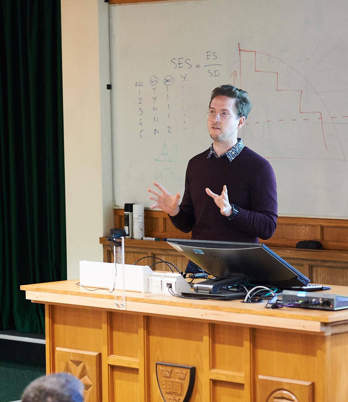 A photo of Oliver Harmson presenting his research to Unit colleagues