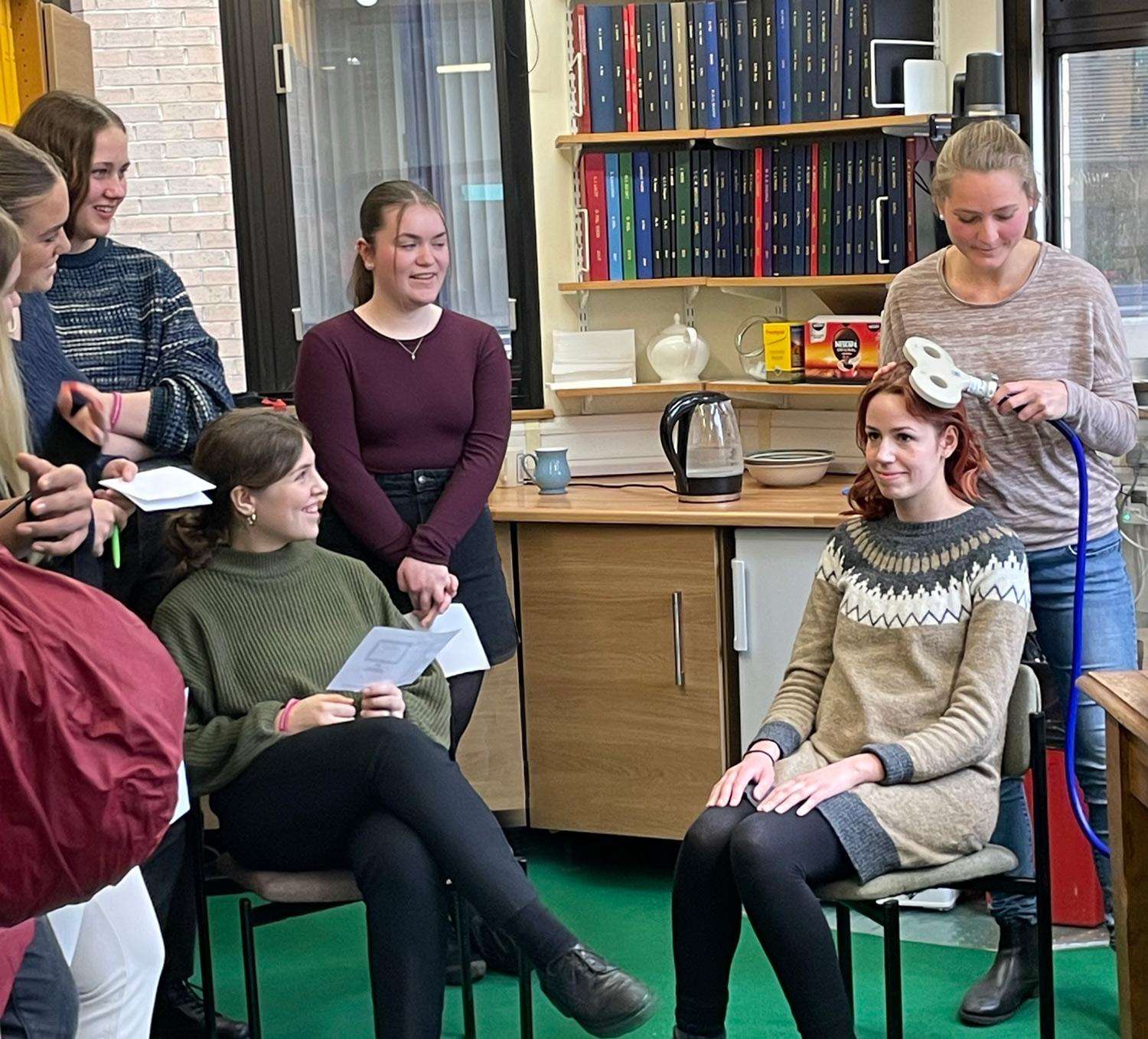 schoool pupils watching a demonstration of transcranial magnetic stimulation