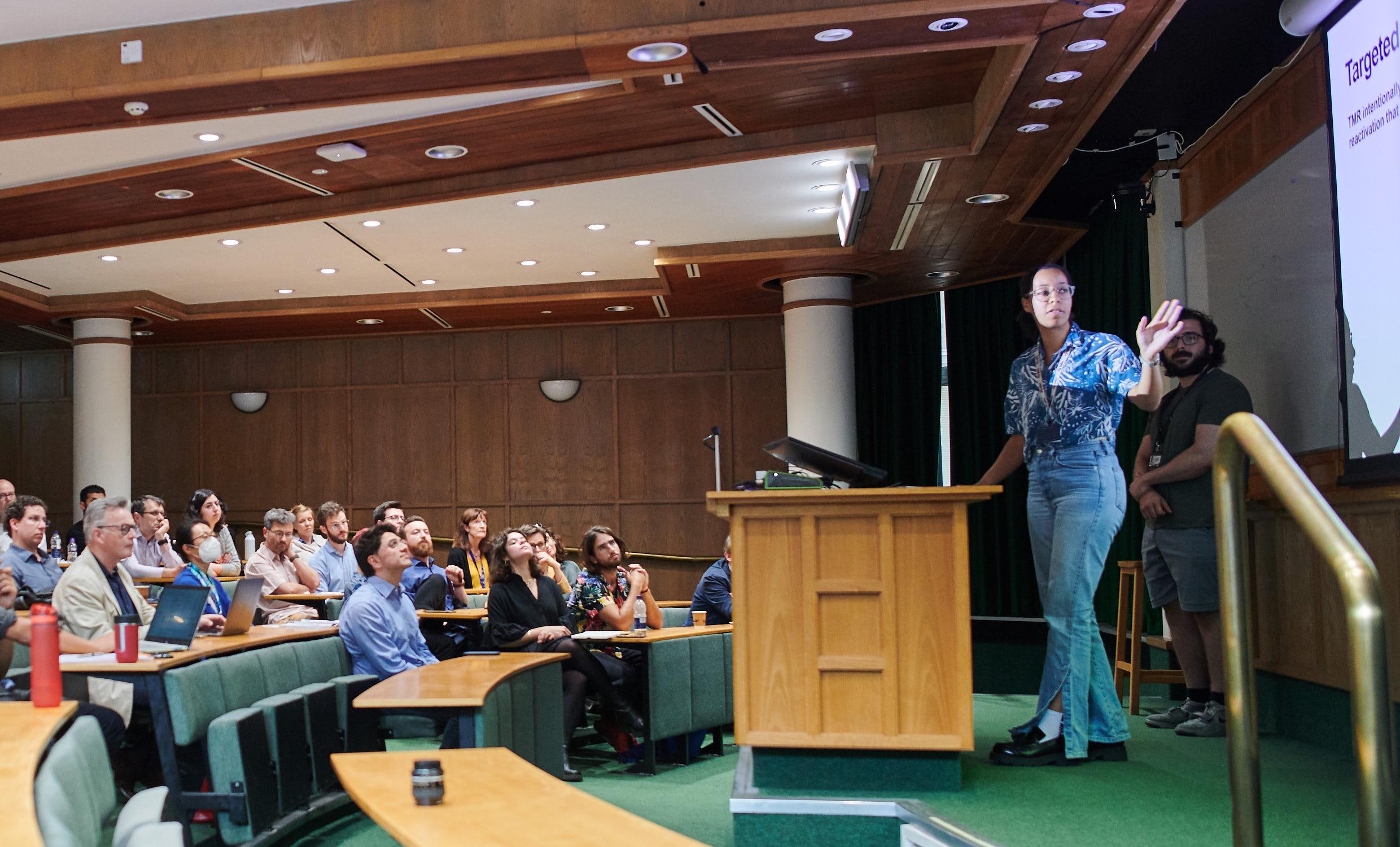 A photo of Morgan Mitchell and Ali Kavoosi presenting their research to Unit colleagues.