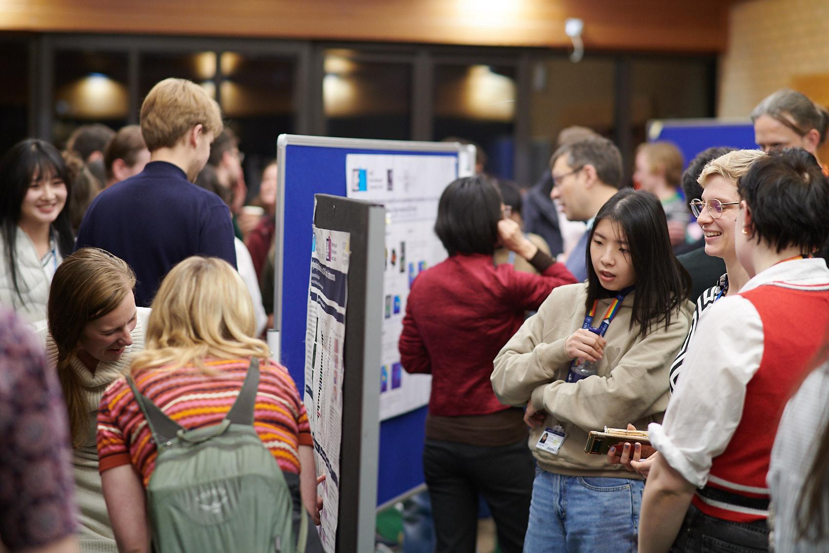 A photo of Unit members talking at the poster session at Winter Science Day 2023.