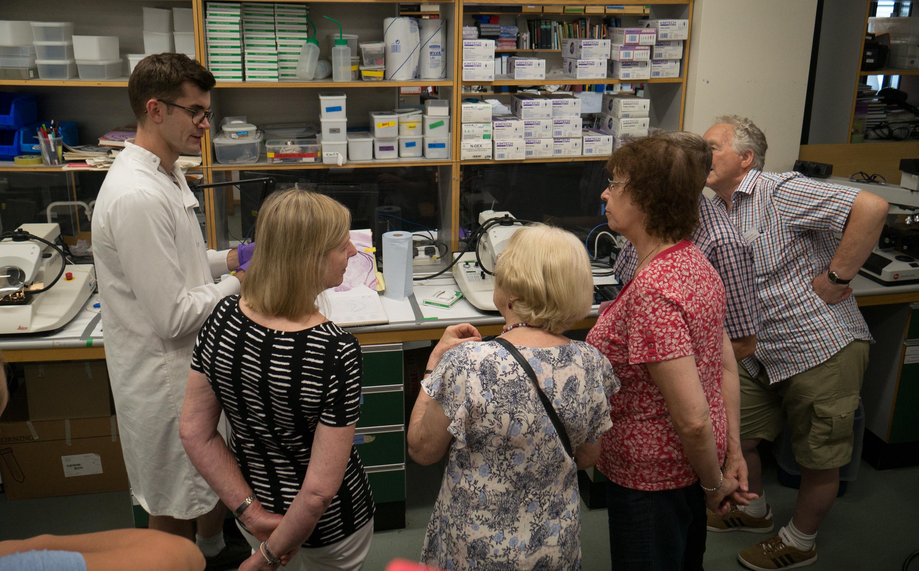 Unit student Luke Bryden (left) engages visitors with his practical demonstration of some of the lab equipment and techniques used at the Unit for its research on Parkinson’s disease.